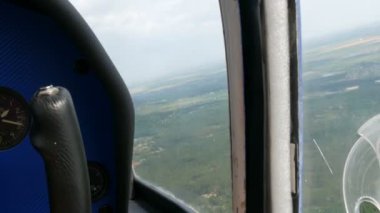 Küçük bir yolcu uçağının lombozunun penceresinden görünen manzara. Metropolün en üst manzarası, bankalarında evler inşa edilen büyük yeşil bir nehirdir. Küçük arabalar.