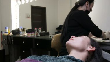 Kozmetik kliniğindeki dudak rengini düzelten özel renk pigmentli mikroplu dövme. Güzellik uzmanı kalıcı makyaj dudak prosedürü yapıyor. Dövme makinesiyle dudaklara pigment makyajı uyguluyor.