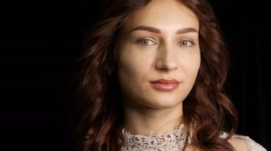 Kalıcı dudak makyajı ve stüdyo kamerasının önünde poz veren mikropatenli kaş dövmesi olan güzel bir genç kadının portresi.