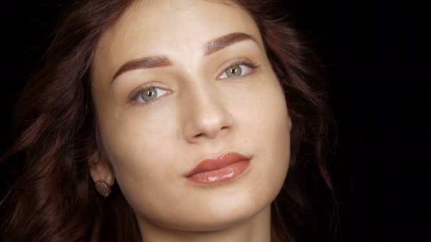 Retrato de una hermosa mujer joven con maquillaje labial permanente y tatuaje de cejas microestocástico posando frente a la cámara en el estudio — Vídeos de Stock