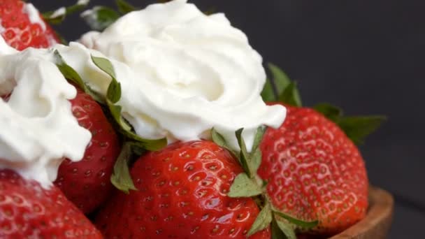 Fresas rojas grandes maduras jugosas en un plato de bambú ecológico en la parte superior con crema batida vista de cerca — Vídeos de Stock