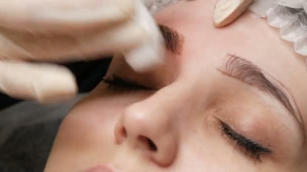 The Microblading Master Wipes His Eyebrows With A Cotton Pad And Disinfects Them Applies Anesthesia Microblading With Eyebrow Tattoo Stock Video C Milkare