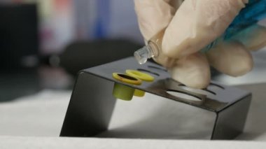 Mikropatenli kaşların dövmesi için özel pigment çözeltisi boyası bir kabın içine dökülüyor, yakın çekim görüntüsü.