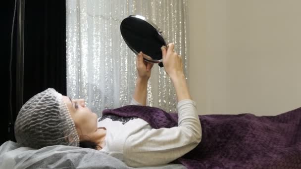 美容室的模特在手术后戴上医疗帽，照镜子 — 图库视频影像