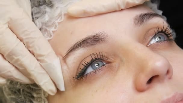 Der Microblading-Meister korrigiert die neue Form der Augenbrauen mit einem speziellen Bleistift. Augenbrauen-Tätowierung, Permanent Makeup — Stockvideo