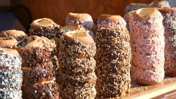 Tschechische Nationalgebäck Trdelnik Brötchen mit verschiedenen Streusel auf dem Streetfood-Festival — Stockvideo