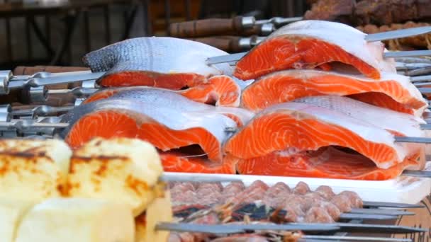 Lachs. Rohe Forellensteaks. Riesige Stücke rotes Fischfleisch am Spieß werden zum Grillen vorbereitet. Picknick im Freien oder Streetfood. Konzept der gesunden Ernährung — Stockvideo