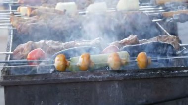 Uzun sıra sebze ve et parçaları ızgarada pişmeye hazır, ızgaradan duman çıkıyor. Sokak yemekleri festivali