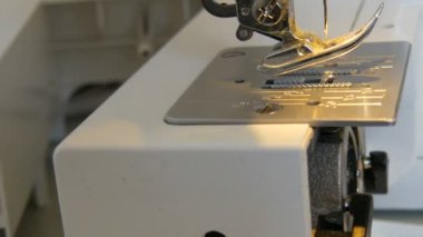 Dikiş makinesinin bir parçası. Ayağın ipliksiz bir iğneyle yakın görüntüsü.