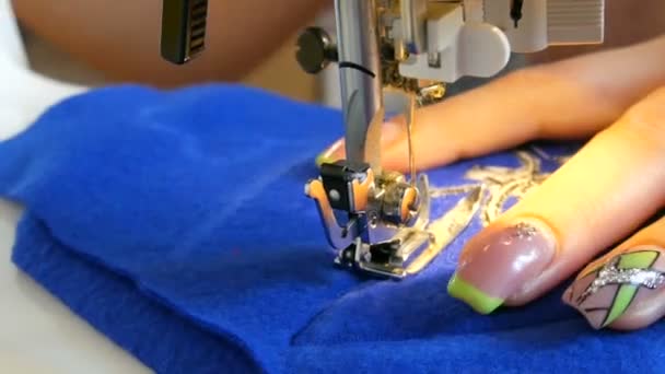 Joven costura de costura de la mano de la mujer cose en una máquina de coser. La aguja y el pie de una máquina de coser con hilo hacen puntadas en la tela — Vídeo de stock