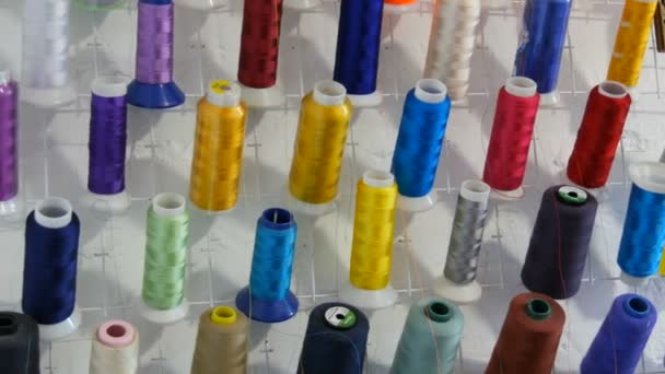 ミシンのための多色の異なる糸の行と縫製ワークショップやアトリエでオーバーロックします。工業用ミシンで異なる色の糸のスプール. — ストック動画
