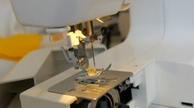 Dikiş makinesinin bir parçası. Ayağın ipliksiz bir iğneyle yakın görüntüsü.
