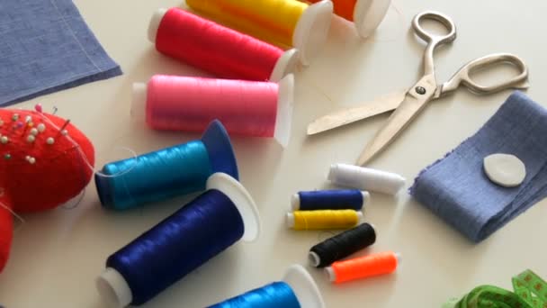 縫製キット、ミシンはさみ、糸でボビン、針でピンク、白いテーブルの背景にセンチメートル。縫製工場、玩具工場 — ストック動画