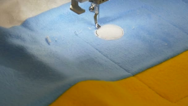 L'ago della macchina per cucire per ricamo fa un ornamento su un pezzo di tessuto azzurro e giallo. Speciale macchina da cucire per ricamo al lavoro. Macchina da cucire programmabile — Video Stock