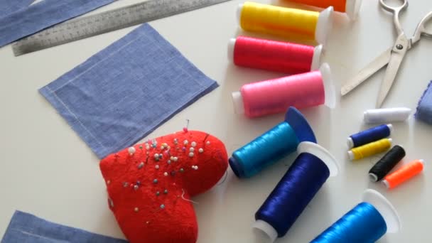 縫製キット、ミシンはさみ、糸でボビン、針でピンク、白いテーブルの背景にセンチメートル。縫製工場、玩具工場 — ストック動画