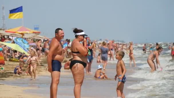 Schastlivtsevo, Ουκρανία - 2 Αυγούστου 2020: Πολλοί άνθρωποι στην παραλία, ξεκουράζονται στη θάλασσα του Azov. Οι υπερβαρείς οικογένειες στέκονται στην ακτή. Γεμάτη ηλιόλουστη παραλία. Πολλοί άνθρωποι στην παραλία. Ωραίο μέρος διακοπών. — Αρχείο Βίντεο