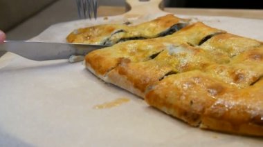 Gürcü restoranında lezzetli bir Gürcü etli turtası, çatal ve bıçakla parçalara ayrılmış. Ulusal otantik mutfak şık yemeklerle servis edilir.