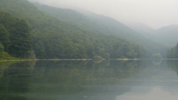 An incredibly beautiful lake with a misty morning haze. Mountain pond with interesting dark water Biorgad Lake in Biogradska Gora National Park, Montenegro — Stock Video