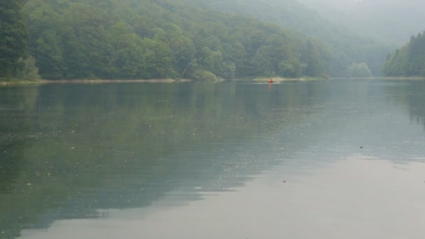 Egy hihetetlenül gyönyörű tó ködös reggeli köddel. Hegyi tó érdekes sötét vízzel Biorgad tó Biogradska Gora Nemzeti Park, Montenegró — Stock videók