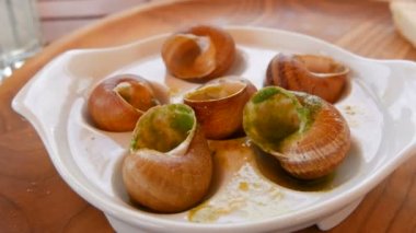 Restoranda özel bir tabakta soslu salyangoz yedi. Pahalı ve sağlıklı yiyecekler, boş kabuklar.
