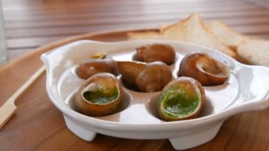 Restoranda özel bir tabakta soslu salyangoz tabağı. Pahalı ve sağlıklı yemekler.
