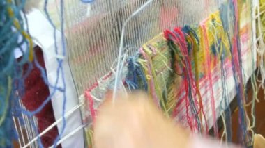 El yapımı halı nakışı. Kadınların elleri çok renkli iplikler kullanarak bir desen oluşturur. Nakış işlemek için çekiç, iplik doldurmak için. Görüntüyü kapat