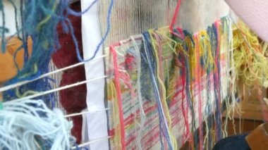 El yapımı halı nakışı. Kadınların elleri çok renkli iplikler kullanarak bir desen oluşturur. Nakış işlemek için çekiç, iplik doldurmak için. Görüntüyü kapat