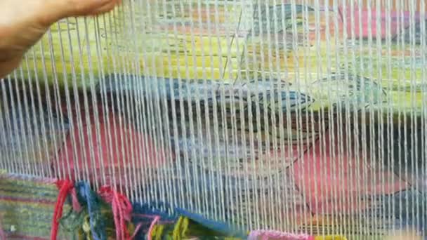 Handgemaakte tapijtborduurwerk. Vrouwen handen maken een patroon met behulp van multi-gekleurde draden. Hamer voor borduurquors, vuldraden. Close-up zicht — Stockvideo