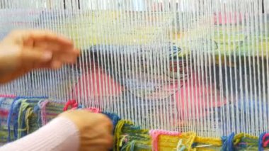 El yapımı halı nakışı. Kadınların elleri çok renkli iplikler kullanarak bir desen oluşturur. Nakış işlemek için çekiç, iplik doldurmak için. Görüntüyü kapat