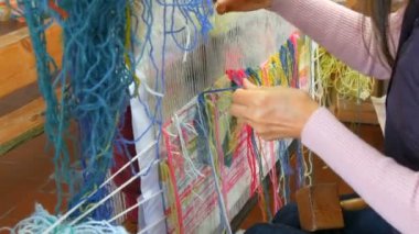 El yapımı halı nakışı. Kadınların elleri çok renkli iplikler kullanarak bir desen oluşturur. Nakış işlemek için çekiç, iplik doldurmak için. Görüntüyü kapat