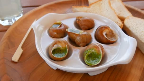 Een kant en klaar gerecht van slakken in een saus op een speciaal bord in een restaurant. Dure en gezonde voeding — Stockvideo