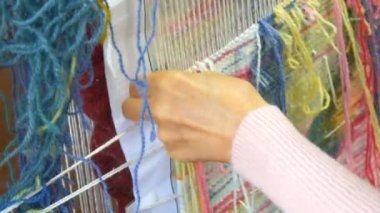 El yapımı halı nakışı. Kadınların elleri çok renkli iplikler kullanarak bir desen oluşturur. Nakış işlemek için çekiç, iplik doldurmak için. Görüntüyü kapat