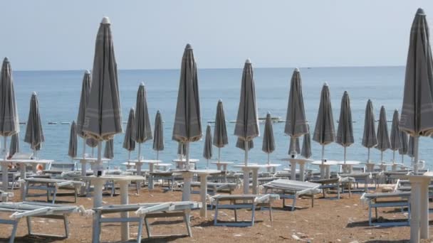 Tomma stranden på kusten av en badort, ensamma solstolar och nära stranden parasoller, slet bort badorten på grund av covid 2019, coronavirus, karantän, Adriatiska havet, Montenegro — Stockvideo