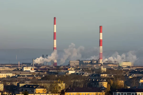 Landscape of smoking chimneys of factories in an industrial city. Dangerous ecology in the industrial city. Smoke and smog from factories and plants.