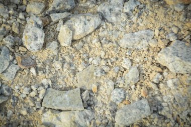 Gri ve beyaz kayaların çeşitli dokusu, küçük çakıl taşları, ve inşaat temalı tasarımlar için ideal olan sarımsı kumlu toprak..