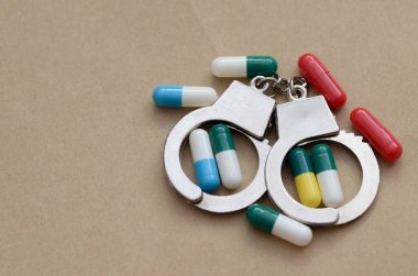 Kelepçe ve ilaçların ikna edici bir düzenlemesi, güçlü uyuşturucu dağıtımı ve kullanımını düzenleyen hukuki çerçeve ve etik soruları vurguluyor.