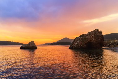 Adriyatik Denizi 'nde gün batımı, Karadağ' ın Budva kenti yakınları, muhteşem deniz manzarası ve doğa manzarası.