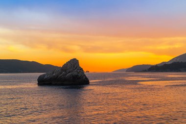 Adriyatik Denizi 'nde gün batımı, Karadağ' ın Budva kenti yakınları, muhteşem deniz manzarası ve doğa manzarası.