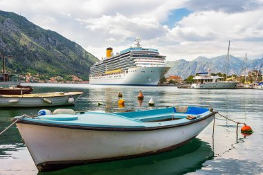 Kotor limanındaki büyük yolcu gemisi dağlarla, Adriyatik denizi, Karadağ ve Akdeniz yaz manzarasıyla çevrili..