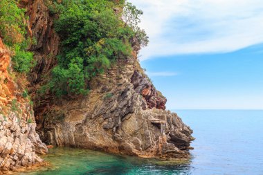 Karadağ 'ın Budva kenti yakınlarındaki Adriyatik kıyı şeridi, kayalıkları ve şeffaf turkuaz sularıyla muhteşem deniz manzarası.
