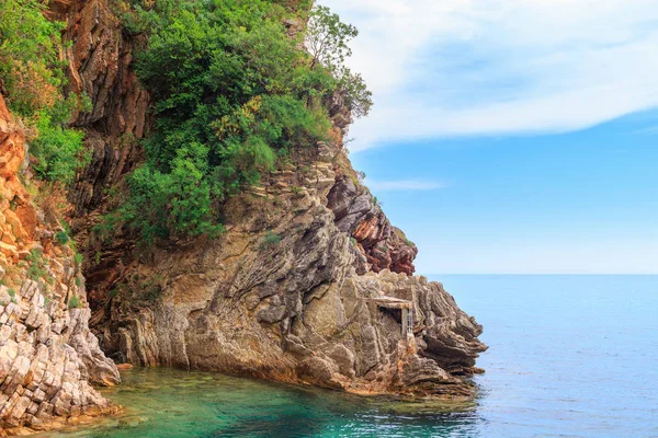 Karadağ 'ın Budva kenti yakınlarındaki Adriyatik kıyı şeridi, kayalıkları ve şeffaf turkuaz sularıyla muhteşem deniz manzarası.