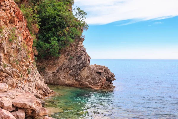 Karadağ 'ın Budva kenti yakınlarındaki Adriyatik kıyı şeridi, kayalıkları ve şeffaf turkuaz sularıyla muhteşem deniz manzarası.