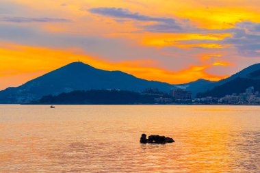 Karadağ 'ın Adriyatik sahil şeridinde altın rengi muhteşem deniz manzaralı gün batımı.
