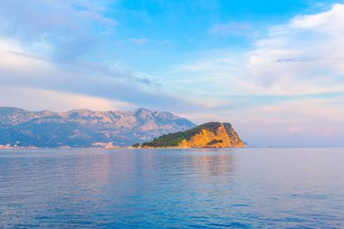 Karadağ 'ın Budva kenti yakınlarındaki Adriyatik Denizi' ndeki Sveti Nikola adası, gün batımından sonra renkli deniz manzarası.