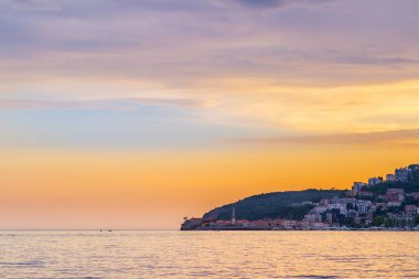 Adriyatik kıyı şeridinde muhteşem gün batımı Karadağ 'daki Budva şehrine bakıyor.
