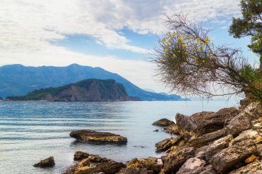 Karadağ 'ın Adriyatik kıyı şeridinde büyük taşlı Mogren plajı ve Sveti Nikola adası.