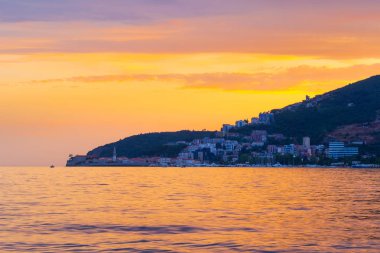Adriyatik kıyı şeridinde muhteşem gün batımı Karadağ 'daki Budva şehrine bakıyor.
