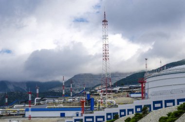 Yağ haznesi yıldırım koruma kuleleri ve boru hatları dağlar çerçevede çevrilidir.