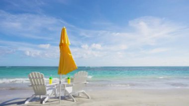 Plajda tatil ve deniz döngüsü videosu. Plaj sandalyeleri ve güneş şemsiyeli Karayip sahillerinde tatil.