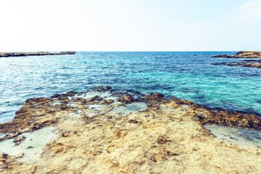 Nissi Beach yaz görünümüne renkli parlak mavi su ve gökyüzü bulutlu. Negatif kopya alanı, metin için yer. Ayia Napa, Kıbrıs